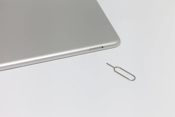 Silver inverted tablet. Visible tray for the SIM card and the key to open