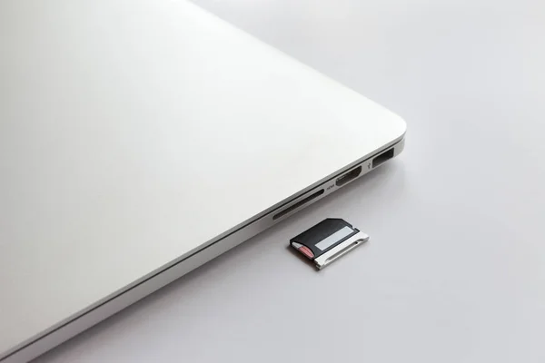 Laptop Metal Fechado Uma Mesa Branca Perto Adaptador Para Leitor — Fotografia de Stock