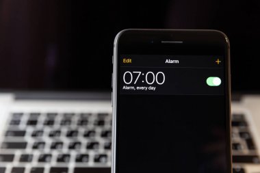 Moskova/Rusya-13 Nisan 2019: siyah iPhone 8 Plus MacBook arka planda. Çalar saat 7 ' ye ayarlanır