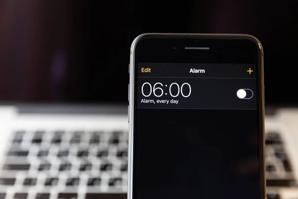 Moskova/Rusya-13 Nisan 2019: siyah iPhone 8 Plus MacBook arka planda. Alarm saati 6 ' da kapalıdır.