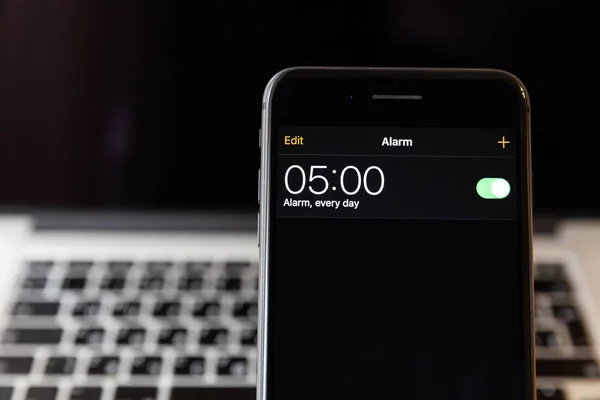 Moskova/Rusya-13 Nisan 2019: siyah iPhone 8 Plus MacBook arka planda. Çalar saat 5 ' e ayarlanmıştır
