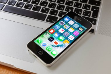 Moskova / Rusya - 11 Mayıs 2019: Beyaz iphone 5c klavye macbook yatıyor. Uygulama ekranında
