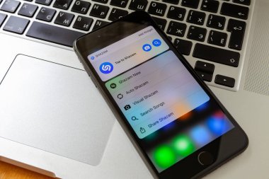 Moskova / Rusya - 14 Mayıs 2019: Macbook'ta siyah iphone. iphone ekranında shazam uygulaması