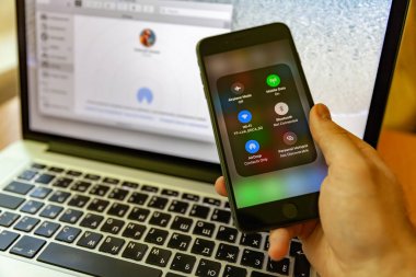 Moskova / Rusya - 17 Mayıs 2019: Elinde siyah iphone, airdrop ekranda. Macbook'un arka planında