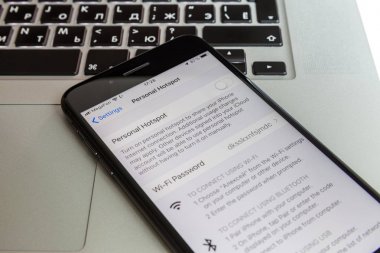 Moskova / Rusya - 10 Temmuz 2019: Black iphone 8 Plus, Macbook klavyede. Modem ekranda kapalı.