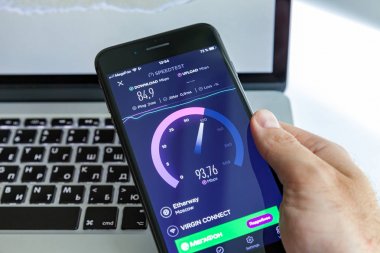 Moskova / Rusya - 13 Temmuz 2019: Macbook'un arka planında siyah iphone 8 Plus. Ekran programı Speedtest