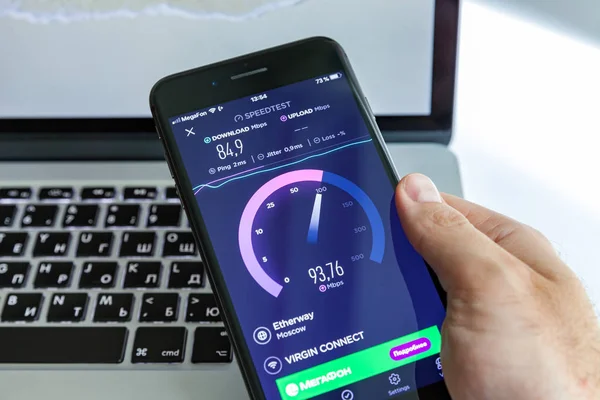 Moskova / Rusya - 13 Temmuz 2019: Macbook'un arka planında siyah iphone 8 Plus. Ekran programı Speedtest
