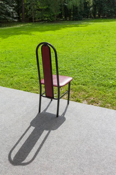 lonely chair with a back against the background of forest and green grass
