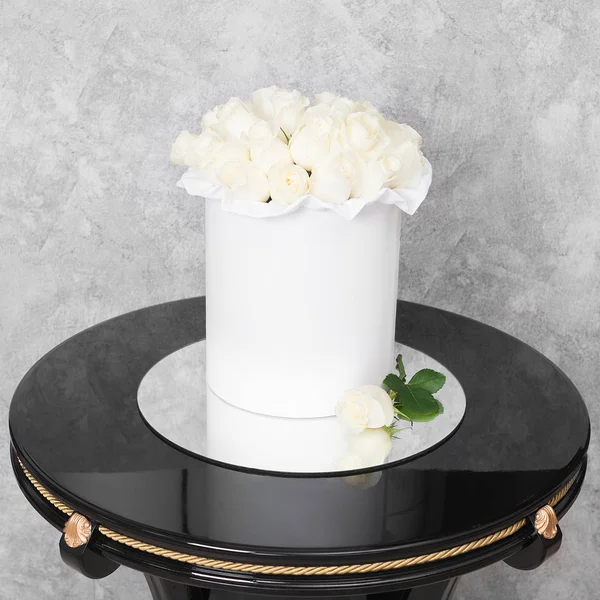 Kytice květin v krabici s kloboukem na stole — Stock fotografie