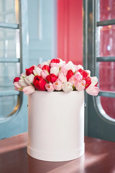 Vacker blombukett i en rund hatt låda på ett bord — Stockfoto