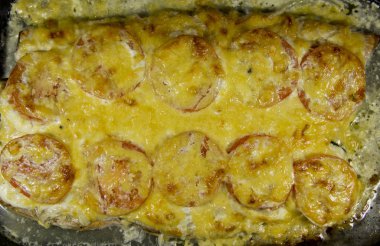 Peynir ve domates ile pişmiş balık.