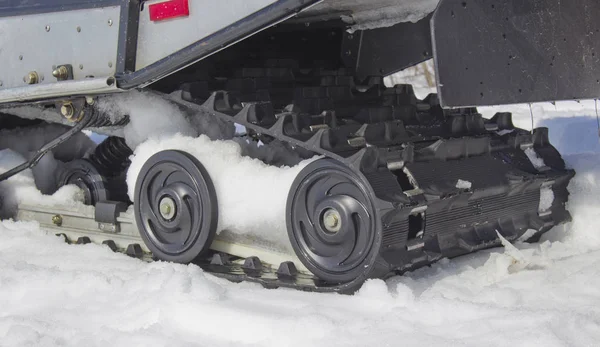 Los rodillos de la moto de nieve sobre la nieve — Foto de Stock