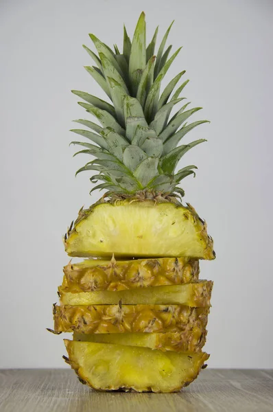 Sliced pineapple on table on light background.