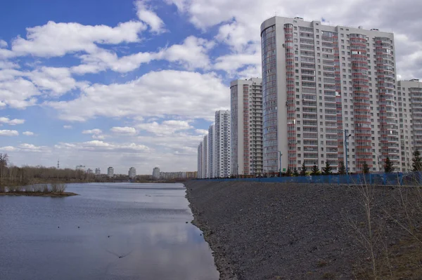 Россия, Красноярск, апрель 2019 года: высокие многоэтажные жилые дома на берегу реки — стоковое фото