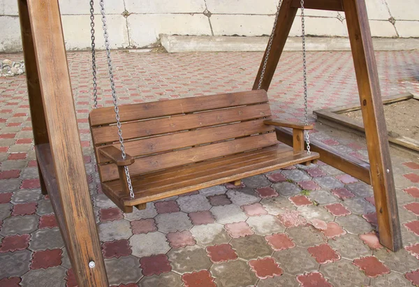 Wooden swing on chains on the platform — Stock Photo, Image