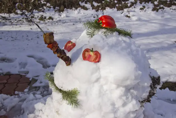 De repente, houve uma grande queda de neve. Um boneco de neve engraçado era feito de neve. Boneco de neve com churrasco no nariz . — Fotografia de Stock