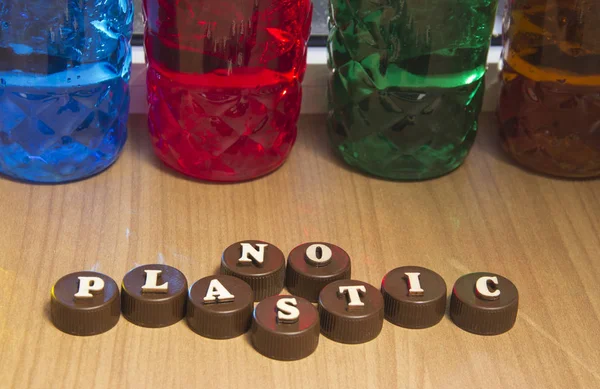 Bez plastiku. Napisy z drewnianych liter na plastikowych nasadkach na butelki. — Zdjęcie stockowe