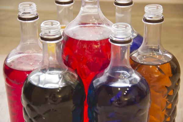 Különböző színű folyadékkal töltött műanyag palackok. — Stock Fotó