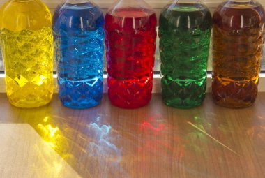 Renkli plastik şişelerden güneş ışınları.