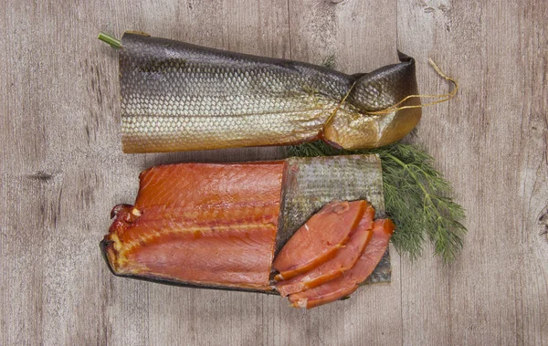 Delicioso peixe defumado no fundo de madeira — Fotografia de Stock