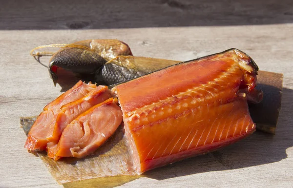 Delicioso peixe defumado no fundo de madeira — Fotografia de Stock