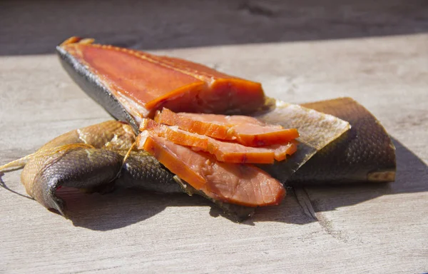 Delicioso peixe defumado no fundo de madeira — Fotografia de Stock