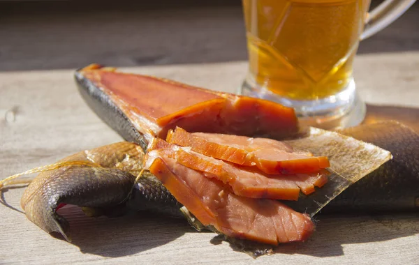 Füstölt hal és egy pohár sör a fából készült háttér — Stock Fotó