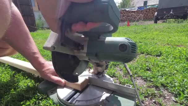 Artesanía del hombre trabaja con herramientas eléctricas al aire libre — Vídeo de stock