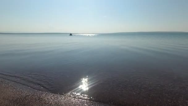 Водная поверхность озера в летний день, водные лодки плавают — стоковое видео