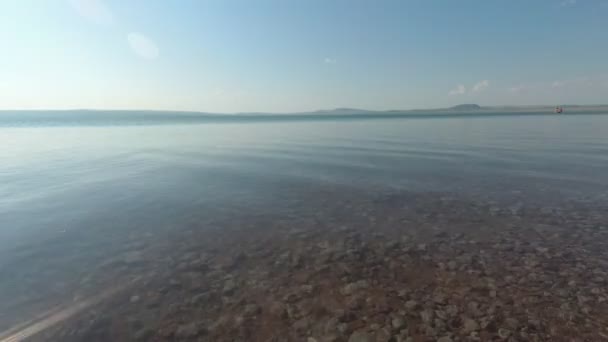 The water surface of the lake on a summer day, the water boats float — Stock Video