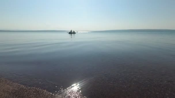 La surface de l'eau du lac un jour d'été, les bateaux flottent — Video
