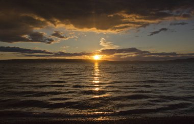 günbatımı, dramatik bulutlar, gölün suda güneşin yansıması