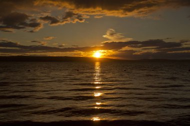 günbatımı, dramatik bulutlar, gölün suda güneşin yansıması