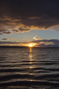 günbatımı, dramatik bulutlar, gölün suda güneşin yansıması