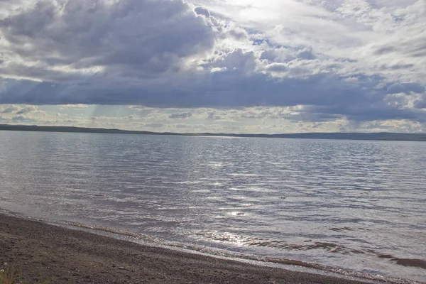 Les rayons du soleil traversent les nuages et illuminent le lac — Photo