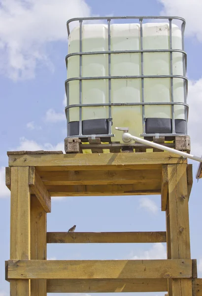 Tanque de água externo em uma base de madeira, a água é encanada na casa — Fotografia de Stock