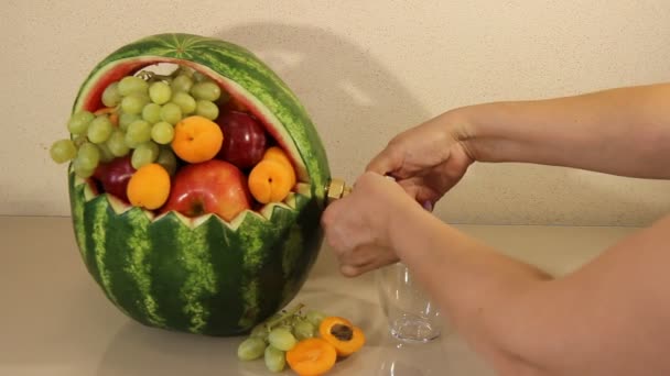 A torneira de melancia c para encher o suco em um fundo leve. o copo de melancia de suco fresco . — Vídeo de Stock