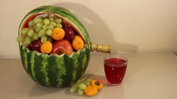 Арбуз с краном, чтобы заполнить сок на светлом фоне. the glass of fresh juice armelon . — стоковое видео