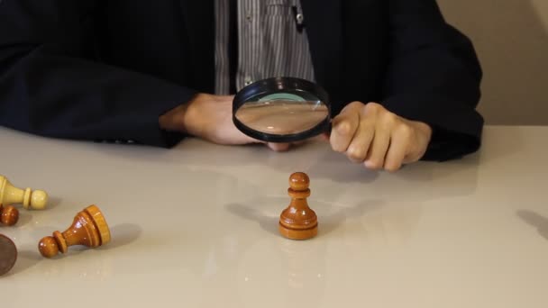 De figuur wordt door een vergrootglas bekeken. Het kiezen van de beste kandidaat. het concept Management Human Resources HR en recruitment — Stockvideo