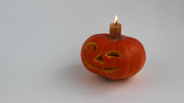 Calabaza de Halloween sobre fondo blanco. Linterna Jack de calabaza jugosa. Vela ardiente . — Vídeo de stock