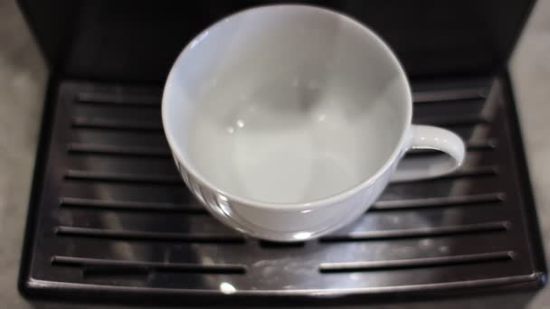 Koffie van de koffiemachine wordt in een witte mok gegoten — Stockvideo