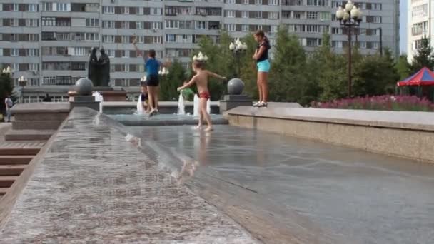 Rusia, Krasnoyarsk, julio de 2019: los niños nadan en una fuente de la ciudad . — Vídeo de stock