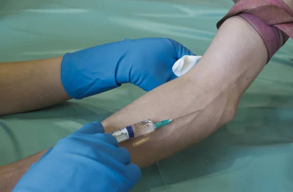 Impfung mit einer Spritze. Injektion, Nadel in der Hand. ein Schuss in die Vene an seinem Arm. — Stockfoto