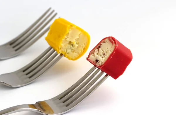 piece of curd cheese on a fork on a white background