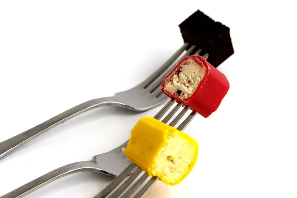 piece of curd cheese on a fork on a white background