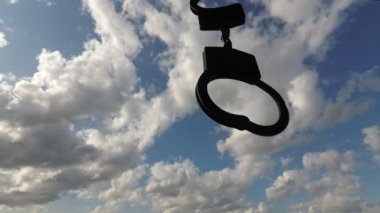kelepçeler ve berrak gökyüzü. Yin-yang felsefe kavramı. İki zıt sembol: gökyüzü özgürlüğü, kelepçe-kölelik.