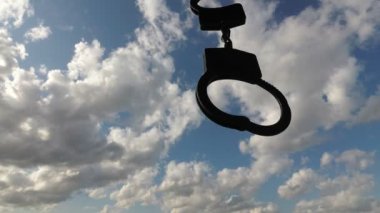 kelepçeler ve berrak gökyüzü. Yin-yang felsefe kavramı. İki zıt sembol: gökyüzü özgürlüğü, kelepçe-kölelik.