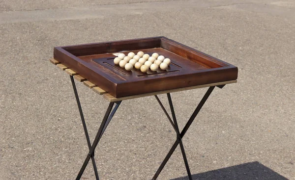 Board game with wooden balls in daylight