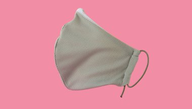 Pembe arka planda tekrar kullanılabilir tıbbi maske. Yan görünüş. Coronavirus COVID-19 salgını. Korona virüsüne karşı korunmak için antiviral tıbbi maske. Cerrahi koruyucu maske. Tıbbi solunum bandajı.