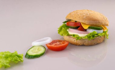 Kahvaltı için sandviç hazırlıyorum. Yansımalı cam bir yüzeyde lezzetli bir burger. Fast food yapma kavramı. Boşluğu kopyala